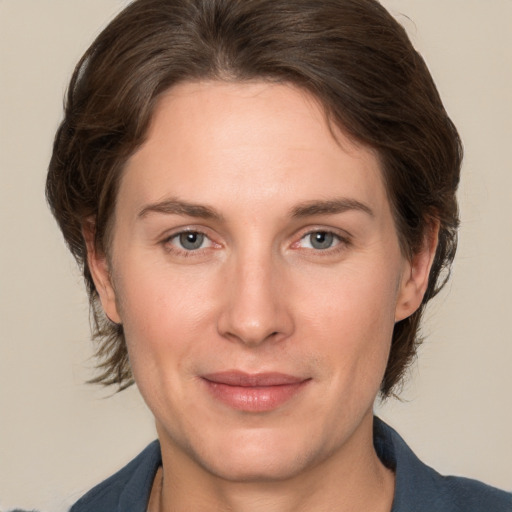 Joyful white adult female with medium  brown hair and grey eyes