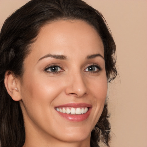 Joyful white young-adult female with long  brown hair and brown eyes