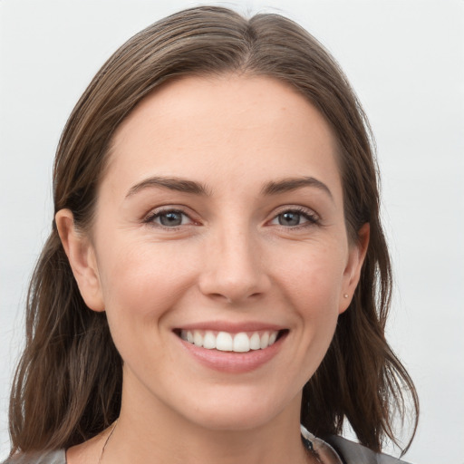 Joyful white young-adult female with medium  brown hair and grey eyes