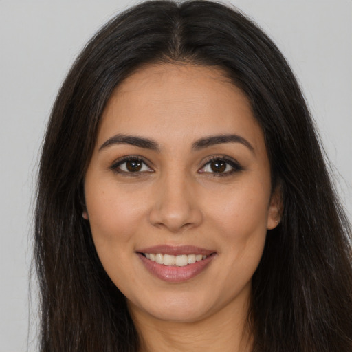 Joyful latino young-adult female with long  brown hair and brown eyes