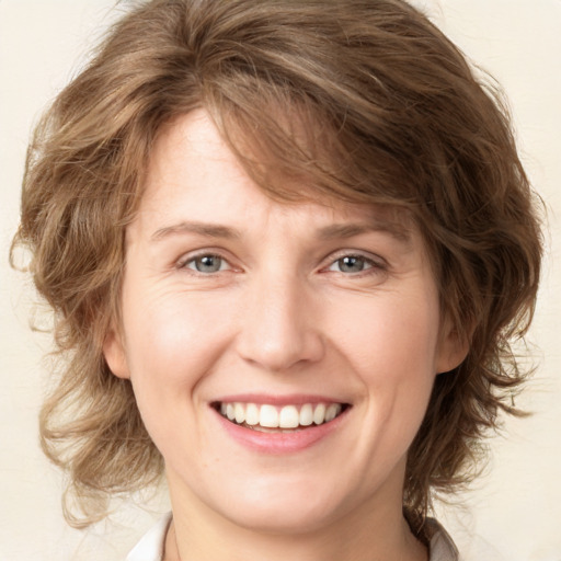 Joyful white young-adult female with medium  brown hair and green eyes