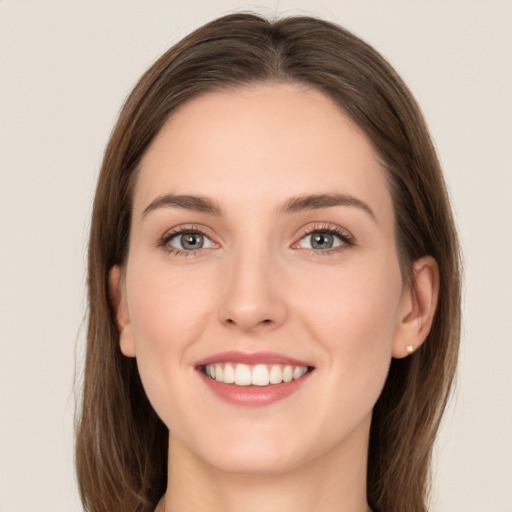 Joyful white young-adult female with long  brown hair and green eyes