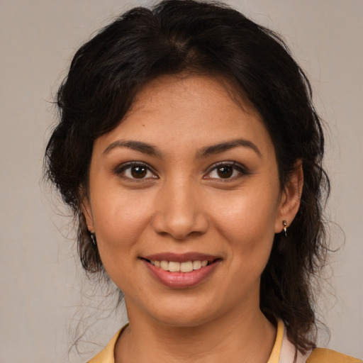 Joyful latino young-adult female with medium  brown hair and brown eyes