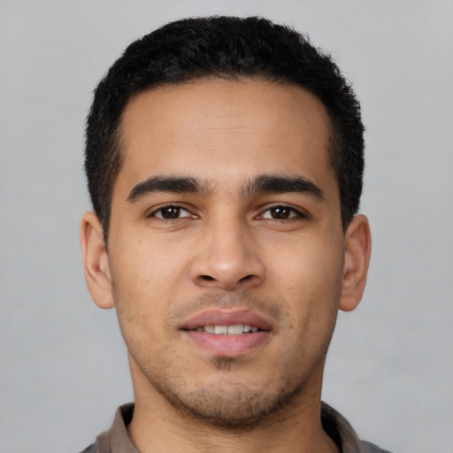 Joyful latino young-adult male with short  brown hair and brown eyes