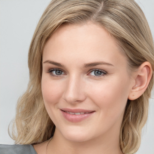 Joyful white young-adult female with medium  brown hair and blue eyes