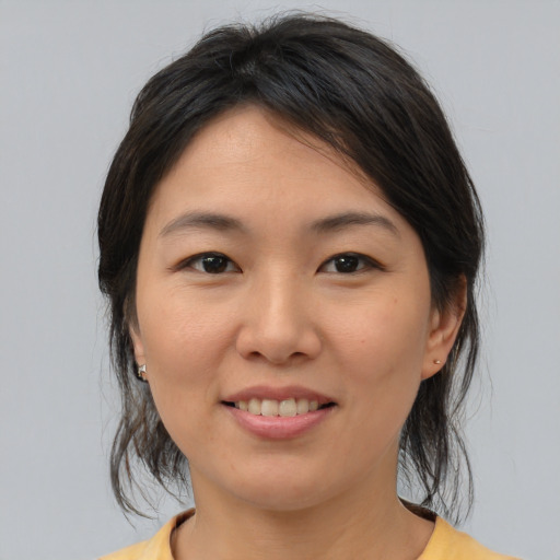 Joyful asian young-adult female with medium  brown hair and brown eyes