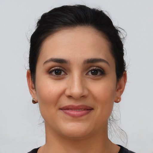 Joyful latino young-adult female with medium  brown hair and brown eyes