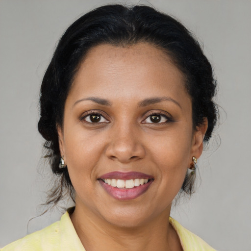 Joyful latino adult female with medium  brown hair and brown eyes
