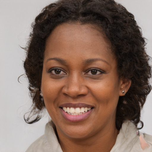 Joyful black young-adult female with medium  brown hair and brown eyes