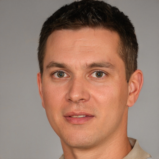 Joyful white young-adult male with short  brown hair and grey eyes