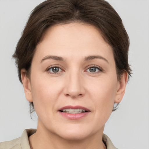 Joyful white adult female with medium  brown hair and grey eyes