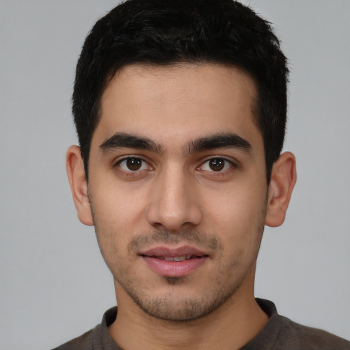 Joyful white young-adult male with short  black hair and brown eyes