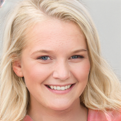 Joyful white young-adult female with long  blond hair and blue eyes