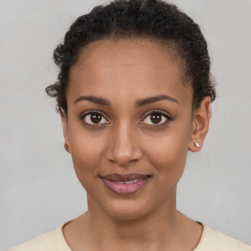 Joyful black young-adult female with short  brown hair and brown eyes