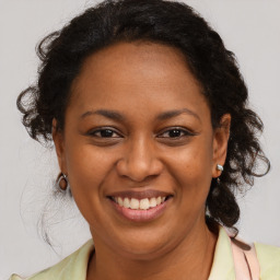 Joyful black adult female with medium  brown hair and brown eyes