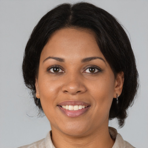 Joyful black young-adult female with medium  brown hair and brown eyes