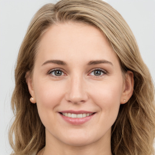 Joyful white young-adult female with long  brown hair and grey eyes