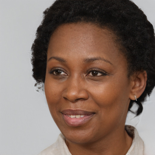 Joyful black adult female with short  brown hair and brown eyes