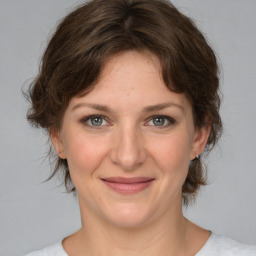 Joyful white young-adult female with medium  brown hair and green eyes