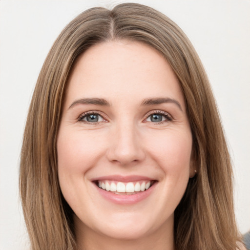 Joyful white young-adult female with long  brown hair and green eyes