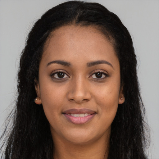 Joyful black young-adult female with long  brown hair and brown eyes