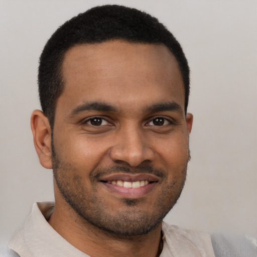 Joyful black young-adult male with short  brown hair and brown eyes