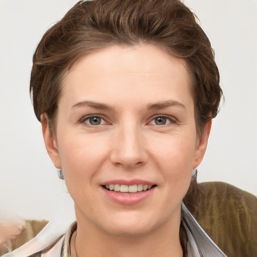 Joyful white young-adult female with short  brown hair and grey eyes