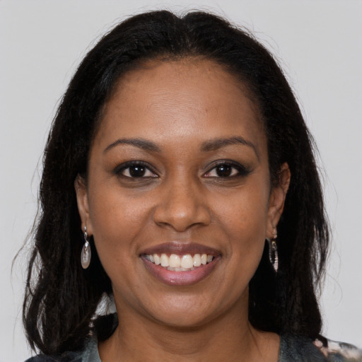 Joyful black young-adult female with long  brown hair and brown eyes