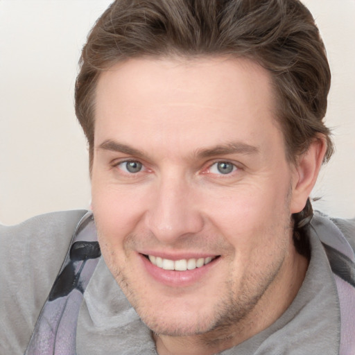 Joyful white adult male with short  brown hair and grey eyes