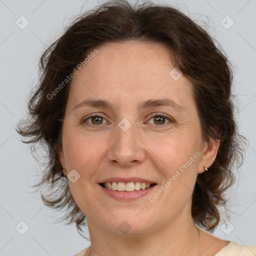 Joyful white adult female with medium  brown hair and green eyes