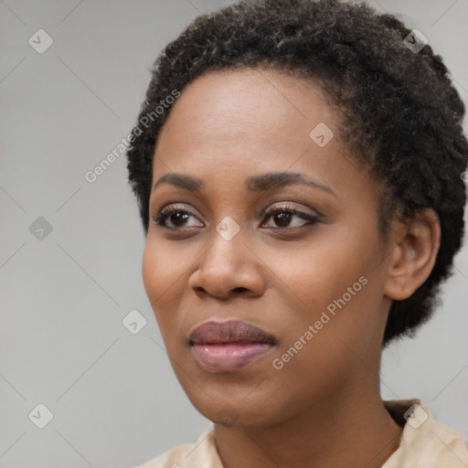 Joyful black young-adult female with short  black hair and brown eyes