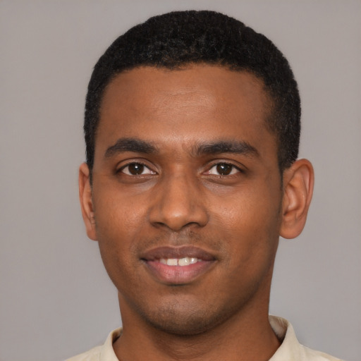 Joyful black young-adult male with short  black hair and brown eyes