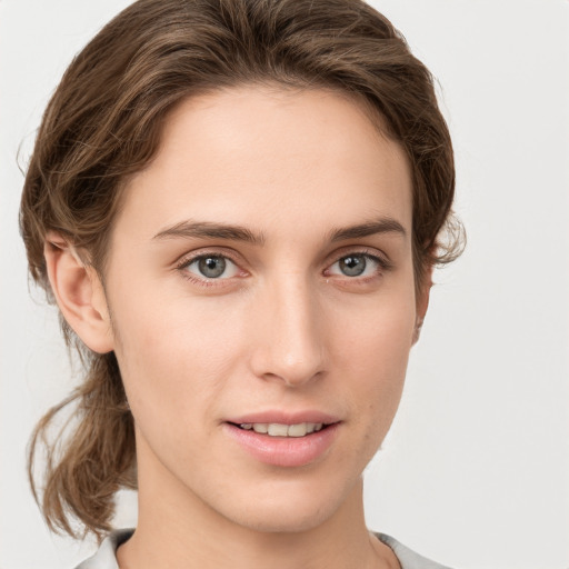 Joyful white young-adult female with medium  brown hair and grey eyes