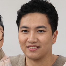 Joyful asian young-adult male with short  black hair and brown eyes