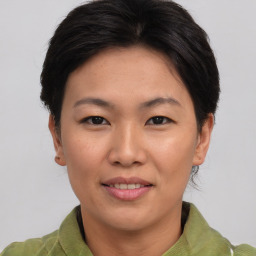 Joyful asian young-adult female with short  brown hair and brown eyes