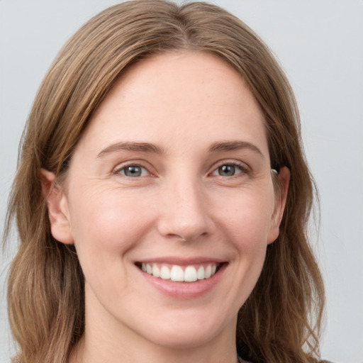 Joyful white young-adult female with long  brown hair and grey eyes