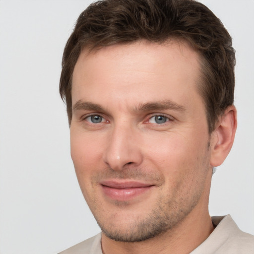 Joyful white young-adult male with short  brown hair and grey eyes