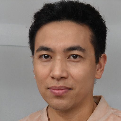 Joyful asian young-adult male with short  black hair and brown eyes