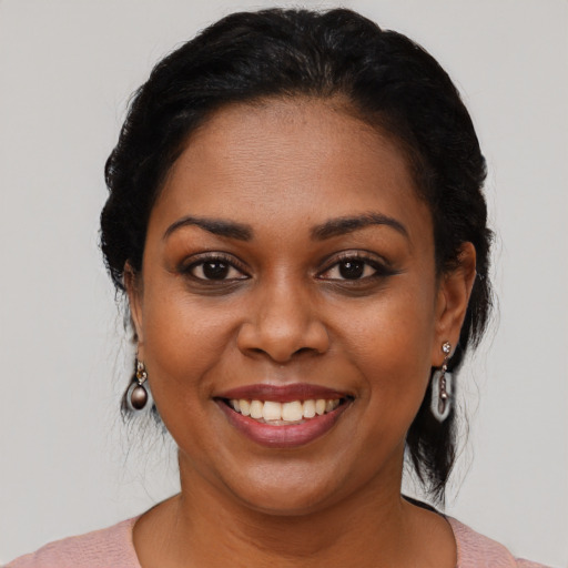 Joyful black young-adult female with medium  black hair and brown eyes