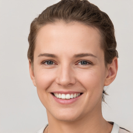 Joyful white young-adult female with short  brown hair and grey eyes