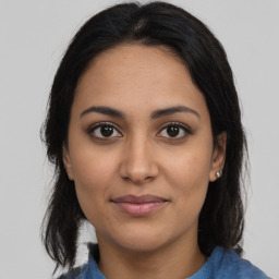 Joyful latino young-adult female with medium  brown hair and brown eyes