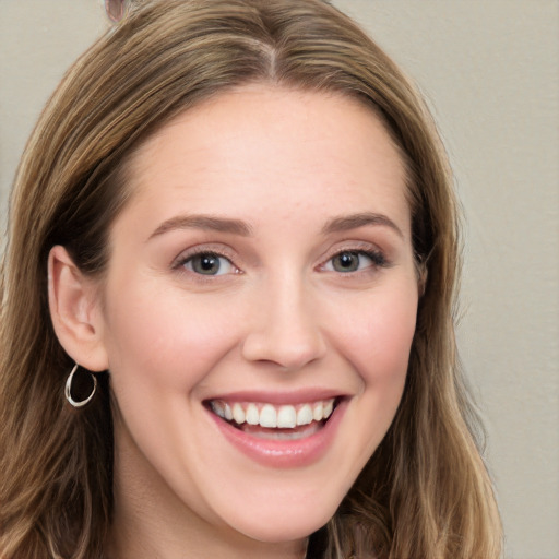 Joyful white young-adult female with long  brown hair and grey eyes