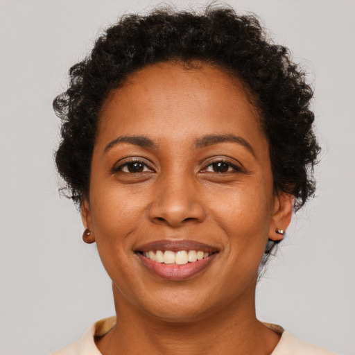 Joyful black adult female with short  brown hair and brown eyes