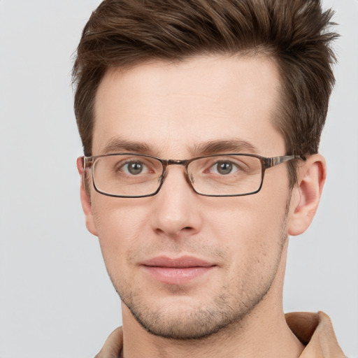 Joyful white young-adult male with short  brown hair and grey eyes