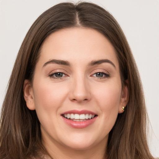 Joyful white young-adult female with long  brown hair and grey eyes