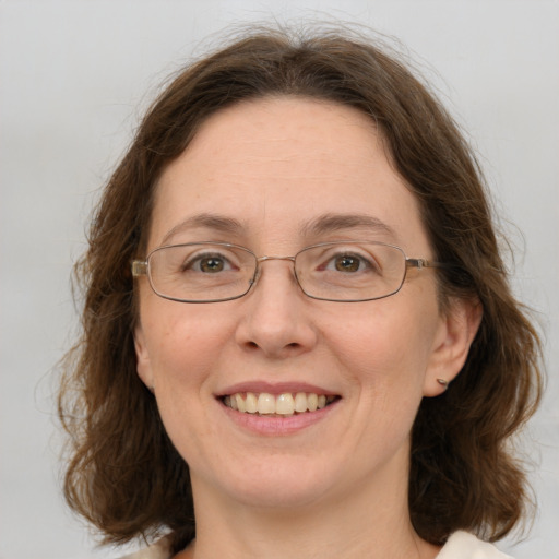 Joyful white adult female with medium  brown hair and green eyes