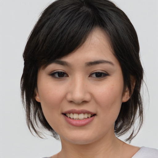 Joyful asian young-adult female with medium  brown hair and brown eyes