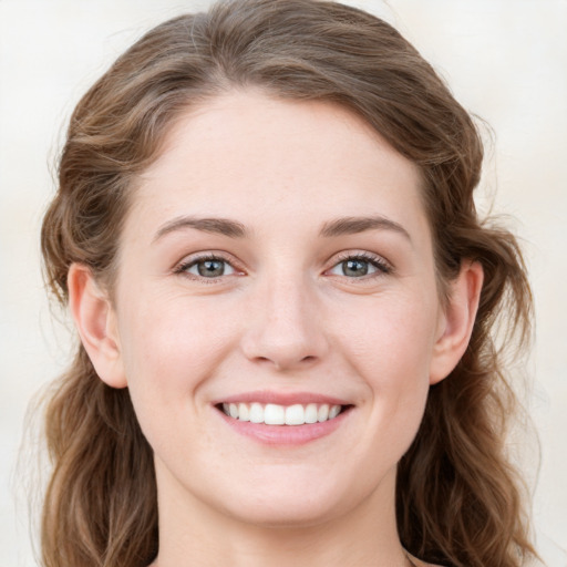 Joyful white young-adult female with long  brown hair and blue eyes