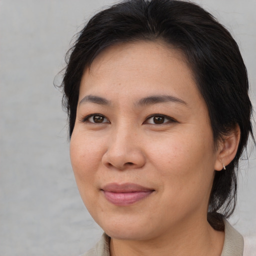 Joyful asian adult female with medium  brown hair and brown eyes