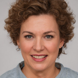 Joyful white adult female with medium  brown hair and blue eyes